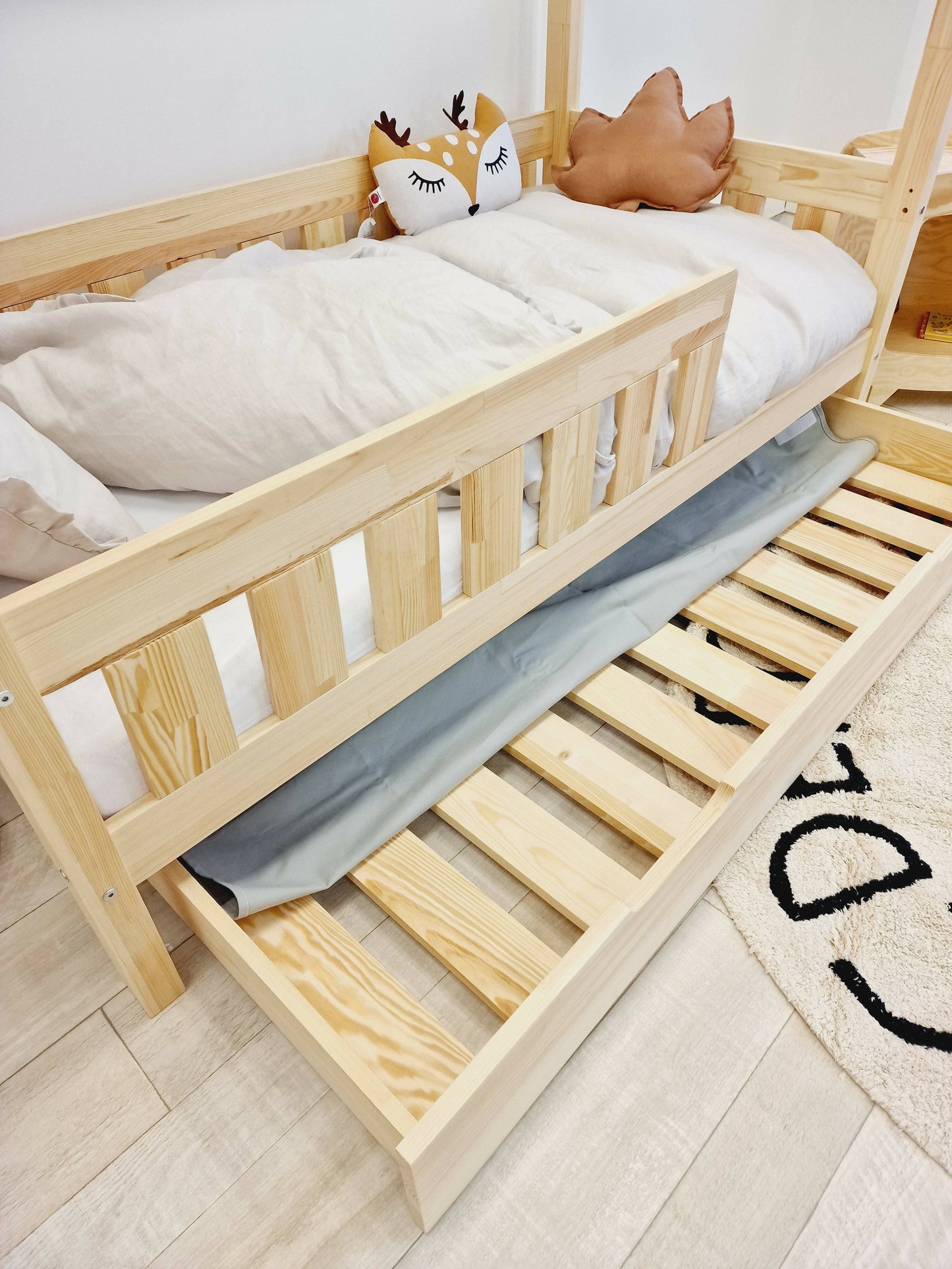 Cama de cabaña infantil con barreras con barras y cajones