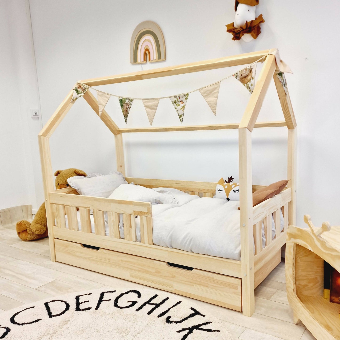 Cama de cabaña infantil con barreras con barras y cajones